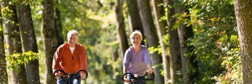 A couple cycling down a tree-lined lane