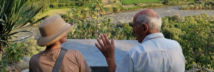 A couple on a bench looking out over a river valley